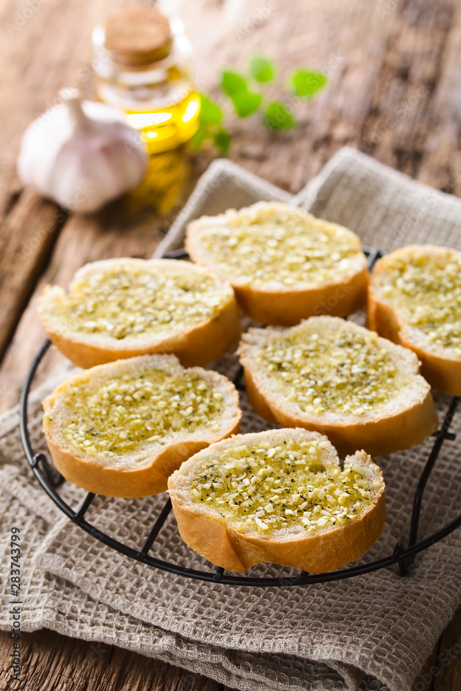 Fresh homemade garlic bread, slices of baguette seasoned with garlic, oregano, salt, pepper and olive oil (Selective Focus, Focus one third into the image) Fresh homemade garlic bread, slices of baguette seasoned with garlic, oregano, salt, pepper and olive oil (Selective Focus, Focus one third into the image)