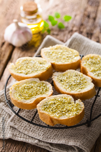 Fresh homemade garlic bread, slices of baguette seasoned with garlic, oregano, salt, pepper and olive oil (Selective Focus, Focus one third into the image)