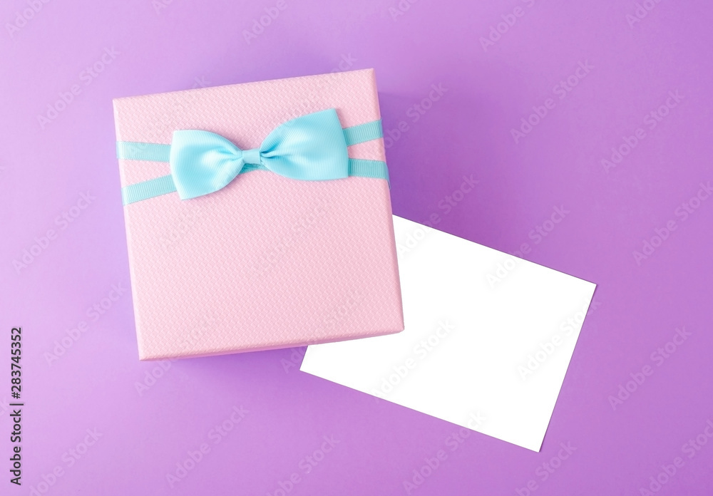 Gift box with bow and white greeting card.