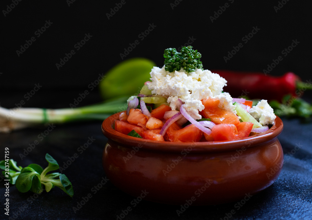 Traditional shopska salad with fresh vegetables and cheese. Traditional Balkan, Serbian, Bulgarian, Macedonian cuisine. Two plates of salad. Black background. Close-up view Traditional shopska salad with fresh vegetables and cheese. Traditional Balkan, Serbian, Bulgarian, Macedonian cuisine. Two plates of salad. Black background. Close-up view