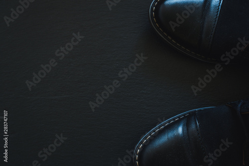 Pair of leather men shoes on black background with copy space - Classic and stylish footwear for businessmen © madrolly