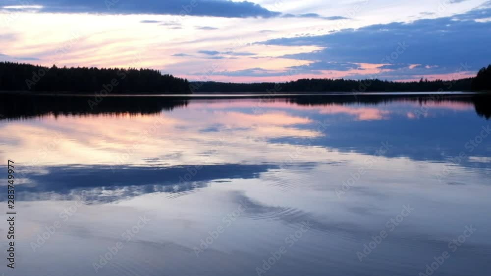 Sunsent on lakeside in Finland. Lake surface wawing calmly. Sunsent on lakeside in Finland. Lake surface wawing calmly.