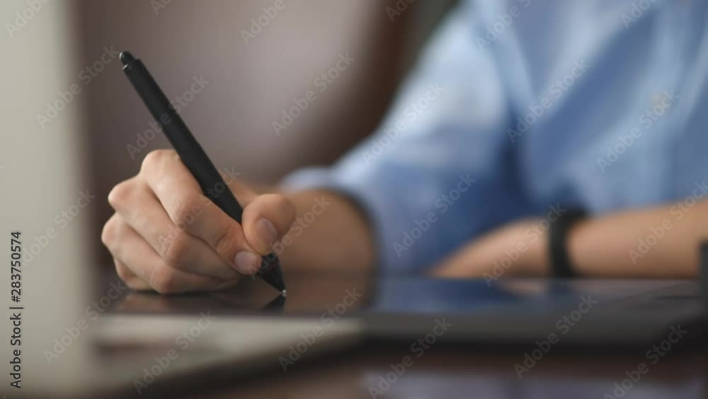 Man drawing on a pen tablet in the office. Close-up shot Man drawing on a pen tablet in the office. Close-up shot