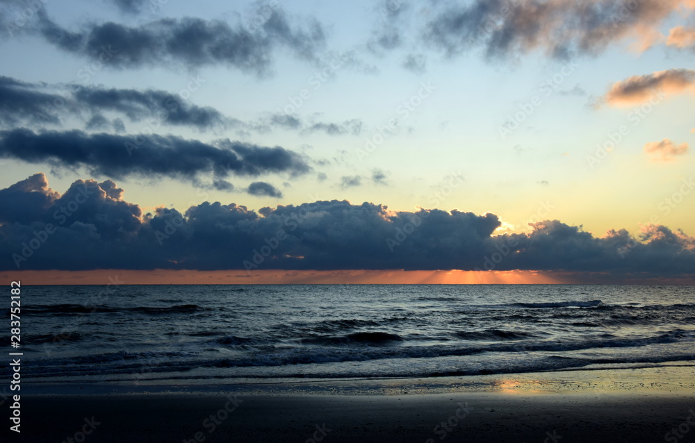 Fototapeta premium Sonnenaufgang über dem Meer mit atemberaubender Wolkenstimmung