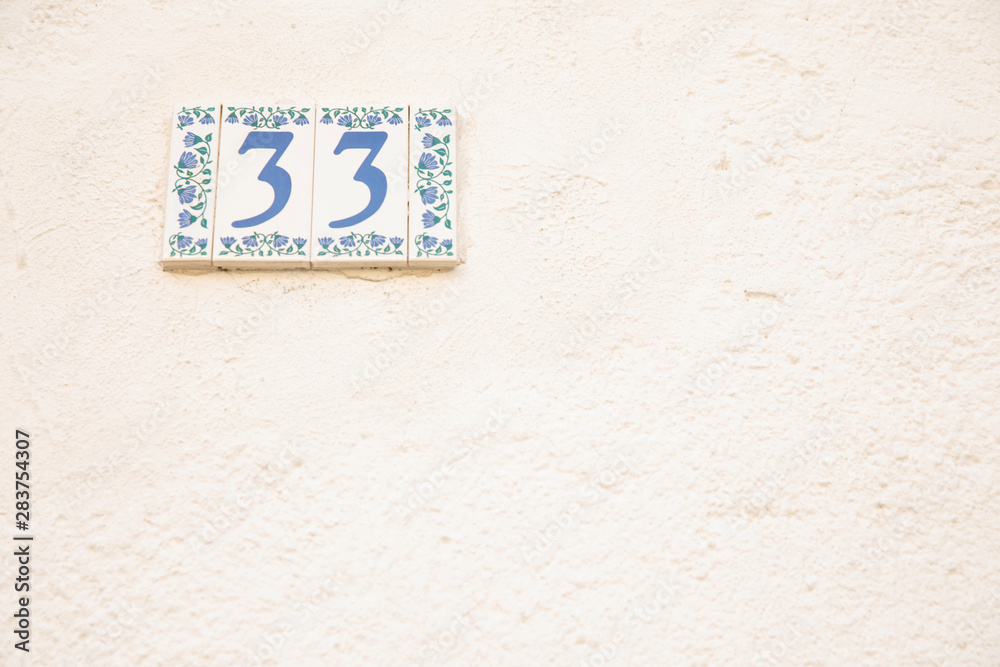 Number 33 street address tile on old wall.
