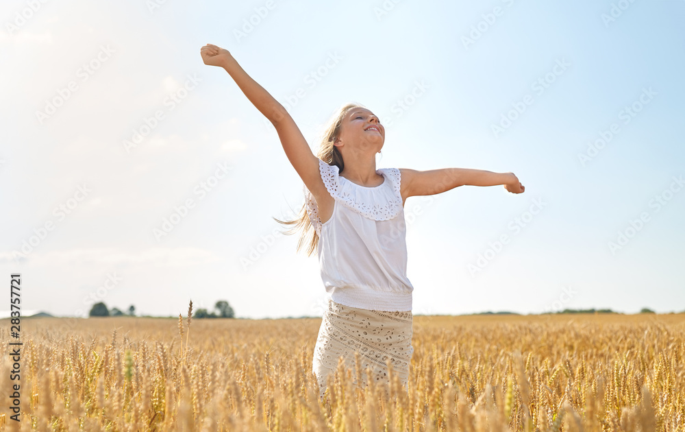 nature, harvest and freedom concept - happy young girl with hands outstretched on cereal field in summer nature, harvest and freedom concept - happy young girl with hands outstretched on cereal field in summer