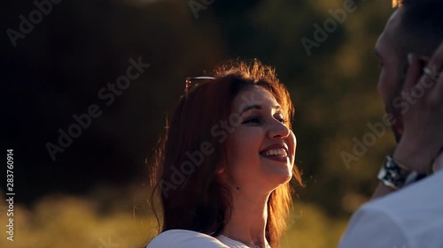 Young man and woman strolling in a meadow at sunset in summer. Romance. Summer love togetherness joy romantic memories forever together concept