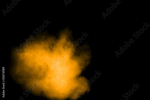 Abstract explosion of orange dust on black background. Freeze motion of orange powder splashing. © Pattadis