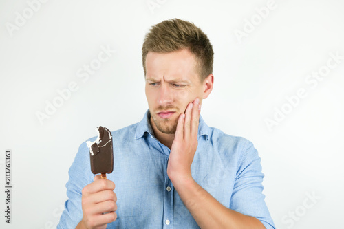 handsome young man just bit cold chololate ice-cream and felt toothache on isolated white background