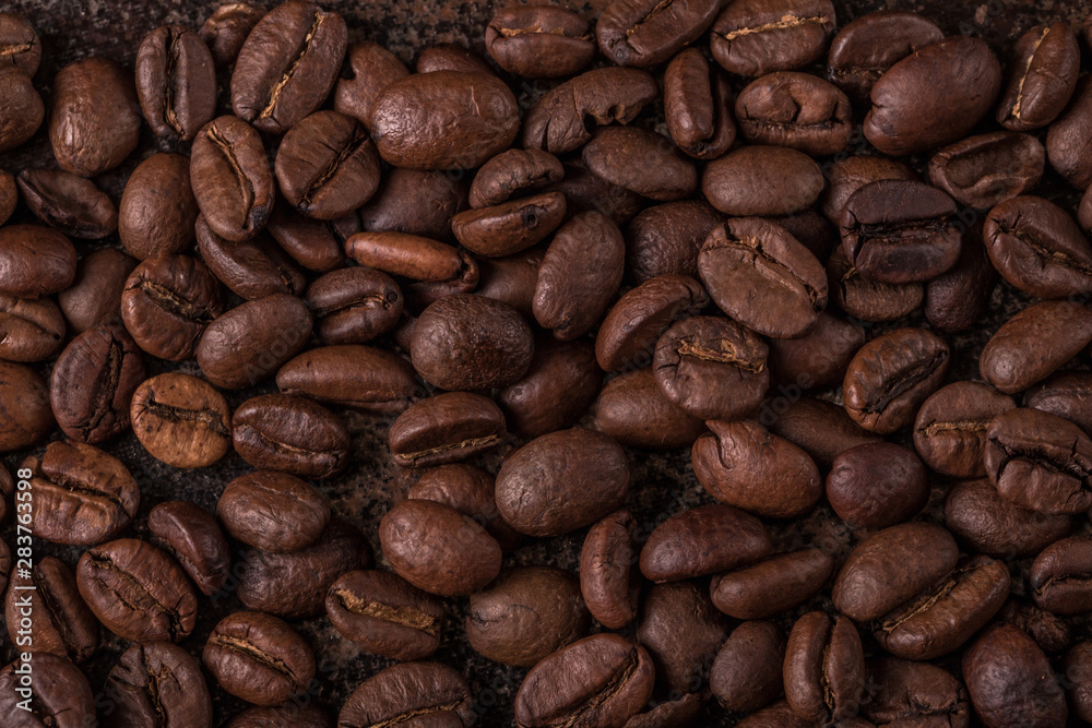 Coffee beans on stone background. Top view with copy space for your text. Roasted coffee beans background. Beans texture, macro Coffee beans on stone background. Top view with copy space for your text. Roasted coffee beans background. Beans texture, macro