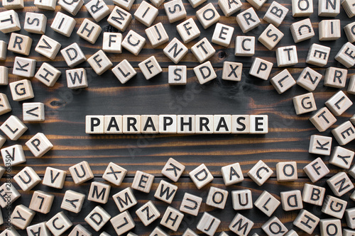 paraphrase - word from wooden blocks with letters, rewrite retelling using other paraphrase words concept, random letters around, top view on wooden background photo