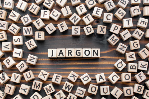 Jargon  - word from wooden blocks with letters,  special words and phrases jargon concept, random letters around, top view on wooden background photo