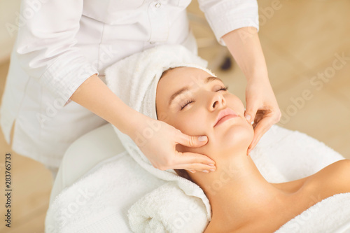 Beautician makes facial massage to the girl