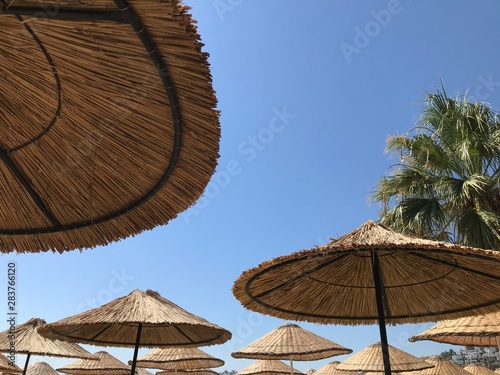 Fototapeta Naklejka Na Ścianę i Meble -  Bamboo sun umbrella against blue sky
