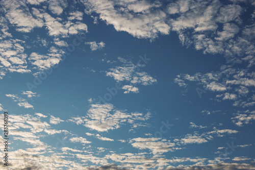 Cirrus cumulus clouds on a blue sky. Background blank texture.