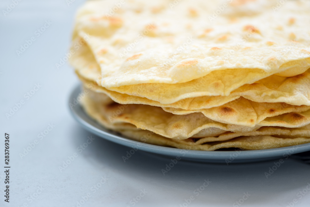 Close up stack of pita, Arabic bread, flatbread on gray wooden background. Soft focus. Traditional arabian food Close up stack of pita, Arabic bread, flatbread on gray wooden background. Soft focus. Traditional arabian food