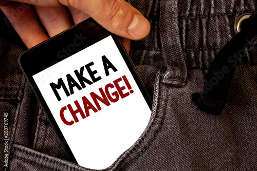 Text sign showing Make A Change Motivational Call. Conceptual photo New Goals Opportunities Different Approach Text two words on white screen black Phone Hand holding grey jeans pocket