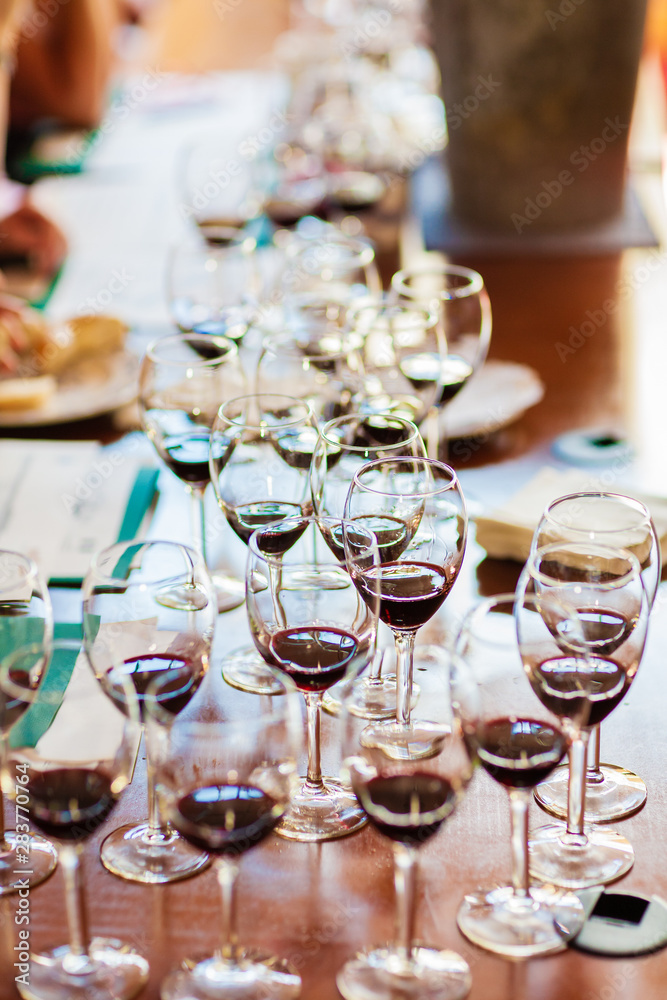 A number of filled red wine glasses ready for wine tasting..