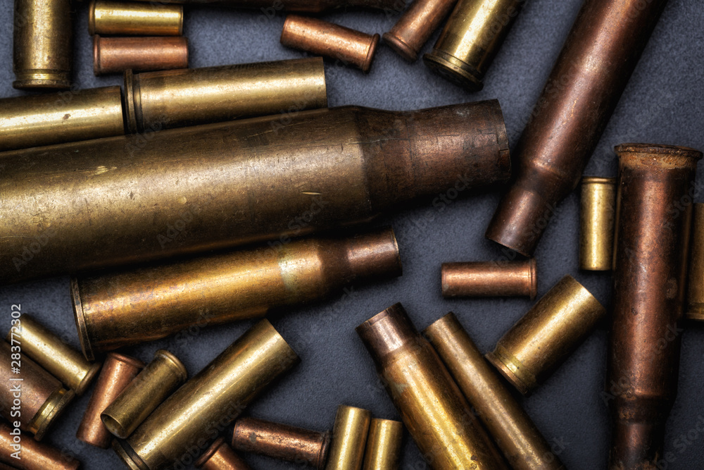 Different size bullet shells on the black ground. War concept. Different size bullet shells on the black ground. War concept.