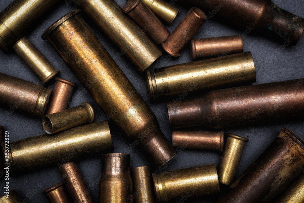 Cases of bullets lying on the black floor. Different size bullet shells. Cases of bullets lying on the black floor. Different size bullet shells.
