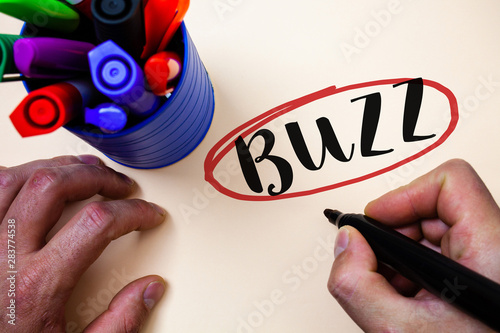 Conceptual hand writing showing Buzz. Business photo text Hum Murmur Drone Fizz Ring Sibilation Whir Alarm Beep Chime Man holding black marker markers table ideas message communicate photo