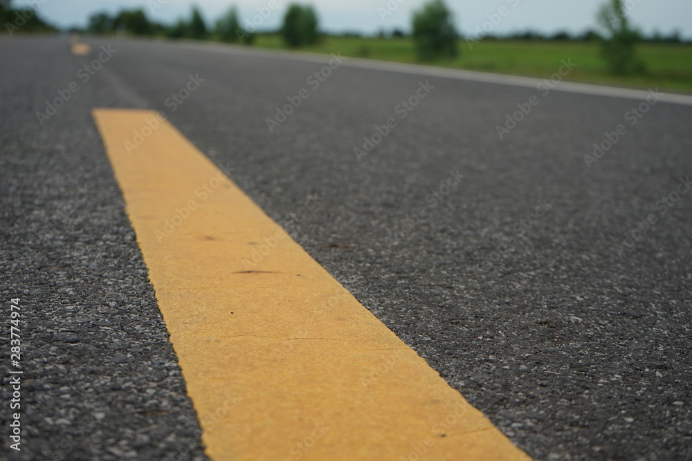 Road traffic paint Yellow on the asphalt surface Road traffic paint Yellow on the asphalt surface