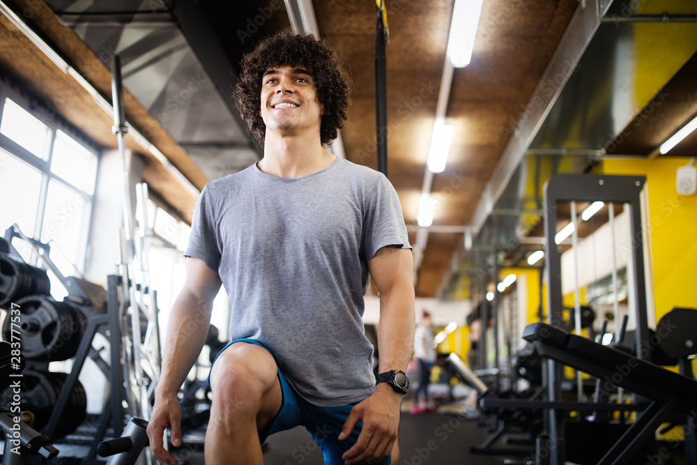Young fit handsome man doing exercises in gym Young fit handsome man doing exercises in gym