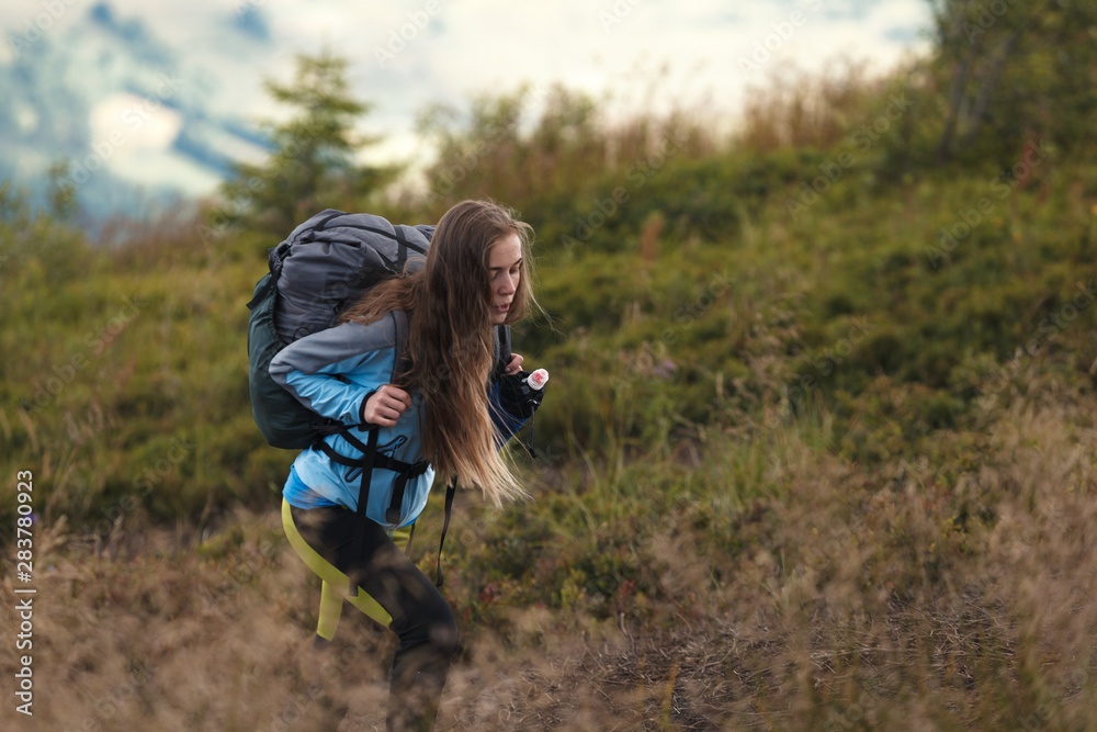 Woman hiking. Hike in the mountains. Woman traveler with backpack on beautiful summer landscape. Woman hiking. Hike in the mountains. Woman traveler with backpack on beautiful summer landscape.