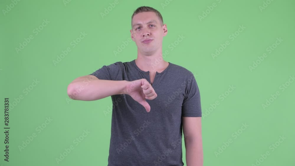 Portrait of sad young man giving thumbs down Portrait of sad young man giving thumbs down