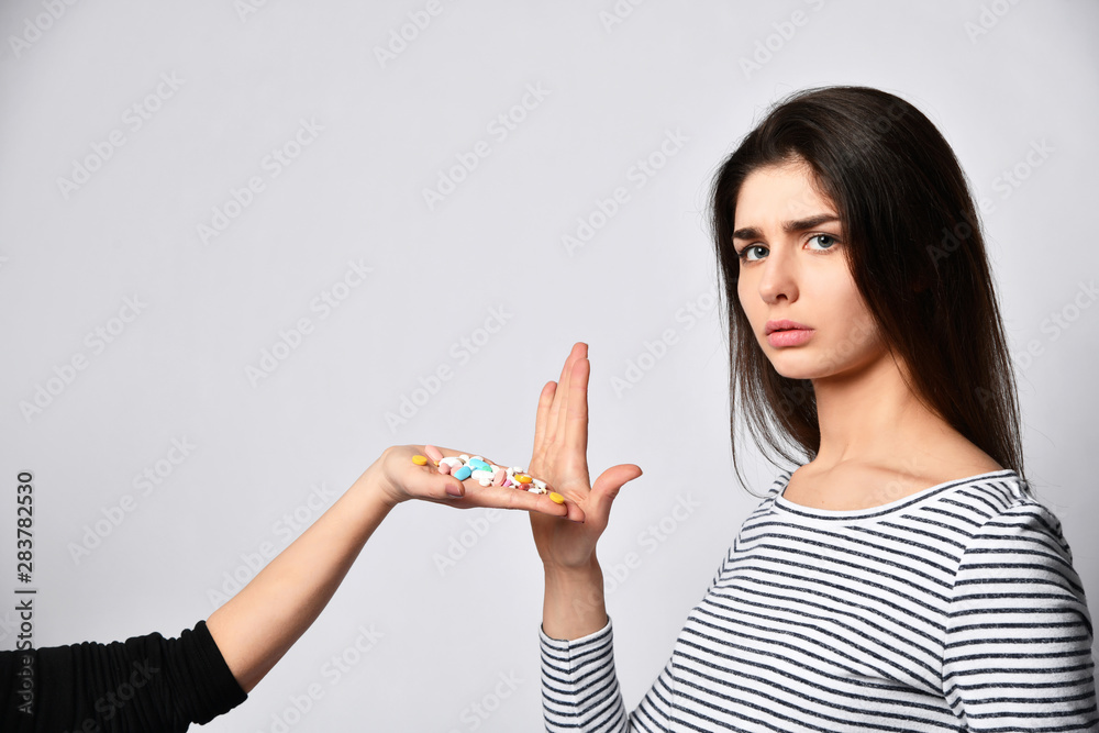 young brunette girl refuses to take pills medicine pills offered on hand young brunette girl refuses to take pills medicine pills offered on hand