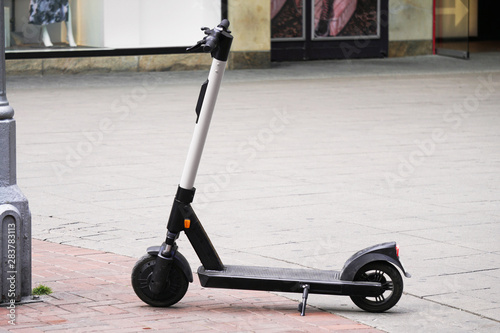 Electric scooter or e-scooter parked on pedestrian street - e-mobility or micro-mobility trend