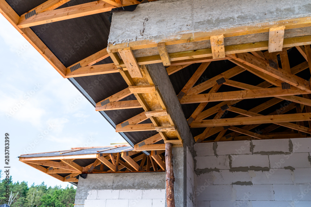 Roof trusses covered with a membrane on a detached house under construction, visible roof elements, battens, counter battens, rafters.