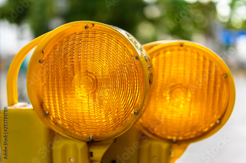 Close up view of two orange warning lights on a construction site.