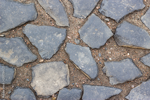 Ancient street pavement made of levelled stones into the ground