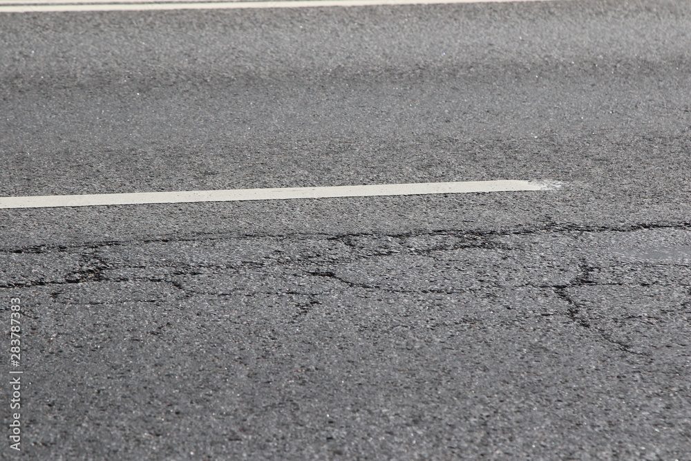 Destroyed asphalt road, close up.