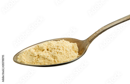 Ginger powder in a spoon isolated on a white background. View from above. Spaces on the isolate.