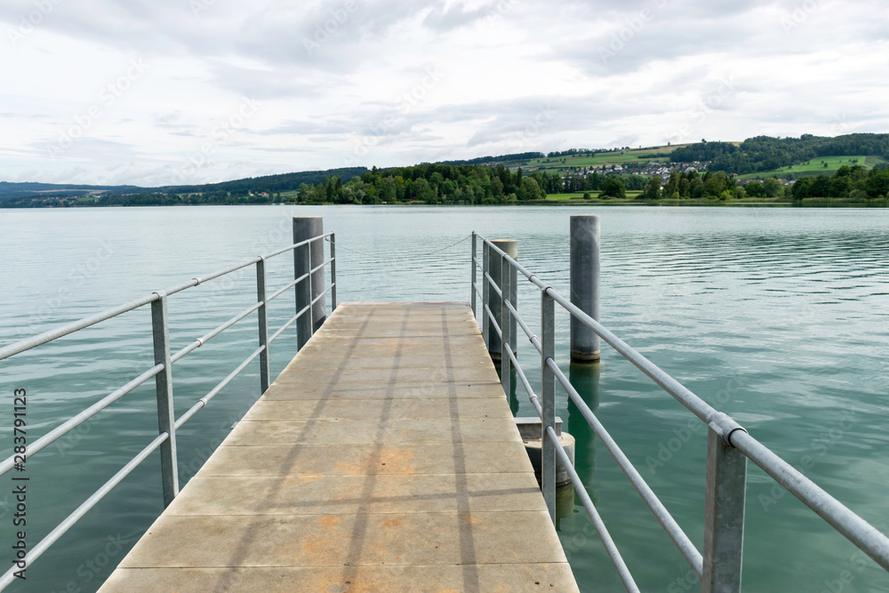 mall dock, calm and clear lake water, sky glare