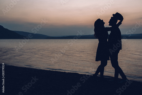 Silhouettes of couple against the sunset sky. Shallow focus © Andriy