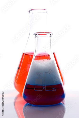 Scientific laboratory glass with blue and red chemical liquid