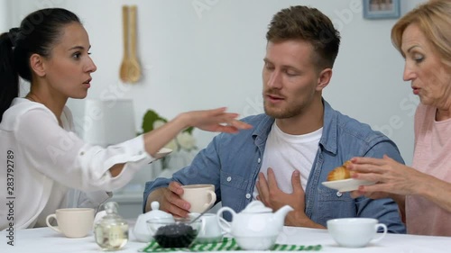 Mother and daughter-in-law competing for man attention treating him with dessert