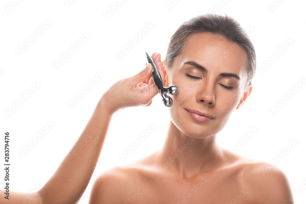 naked young woman using facial massager isolated on white