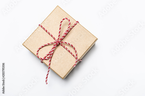 Flat lay overhead gift box with bow on white background, copy space for your design. Minimal composition for sales, New Year, Christmas or birthday.