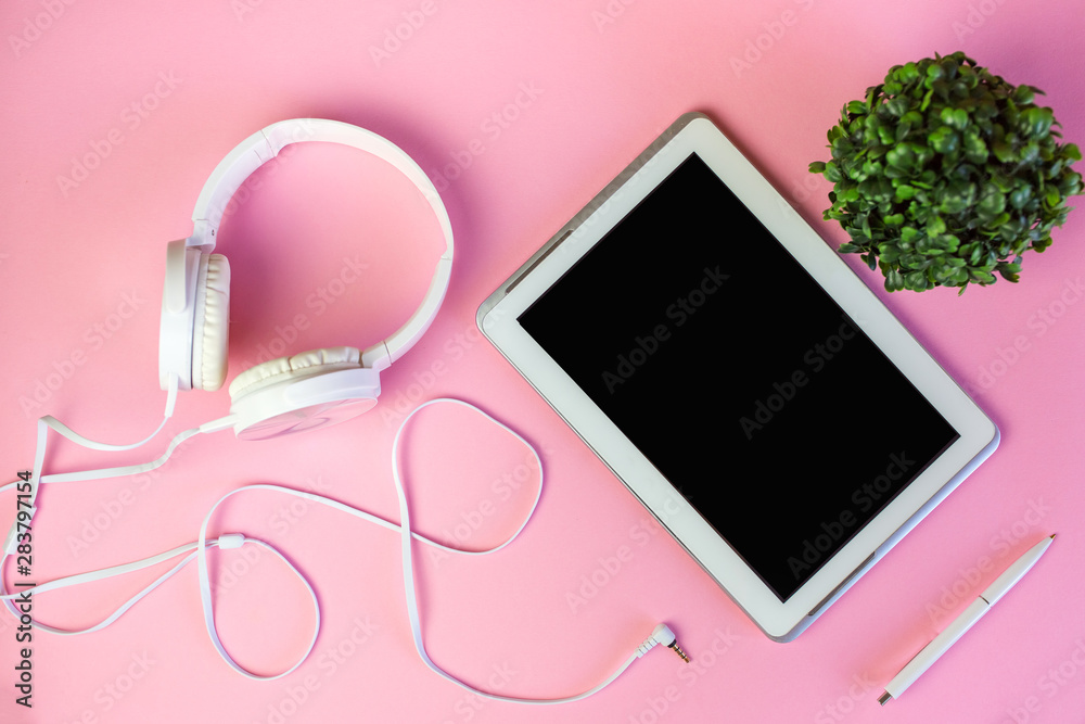 Flat lay of laptop, earphones, digital gadget, modern concept on soft pink background with copy space Flat lay of laptop, earphones, digital gadget, modern concept on soft pink background with copy space