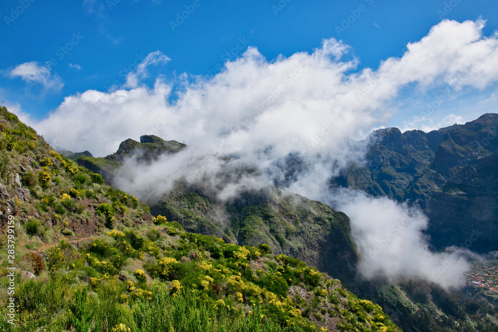 View from the hiking trail at the Boca da Corrida belvedere on the Encumeada pass on Madeira Island, Portugal in summer, View to the village of Curral das Freiras 