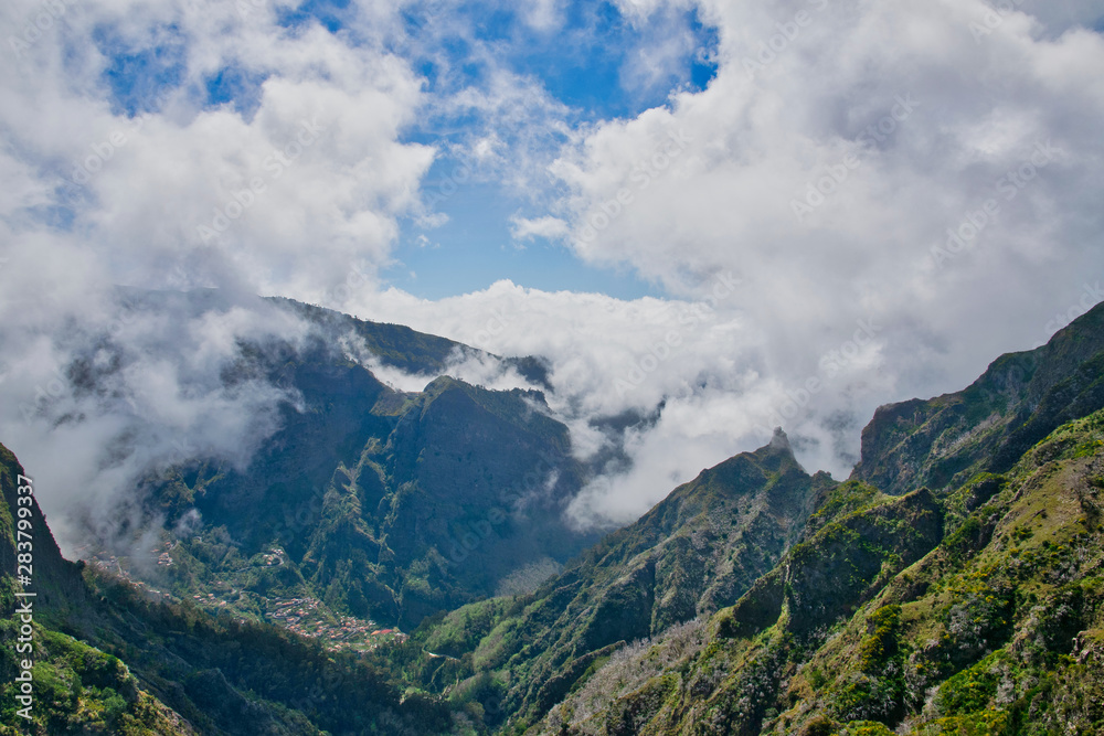 View from the hiking trail at the Boca da Corrida belvedere on the Encumeada pass on Madeira Island, Portugal in summer, View to the village of Curral das Freiras 