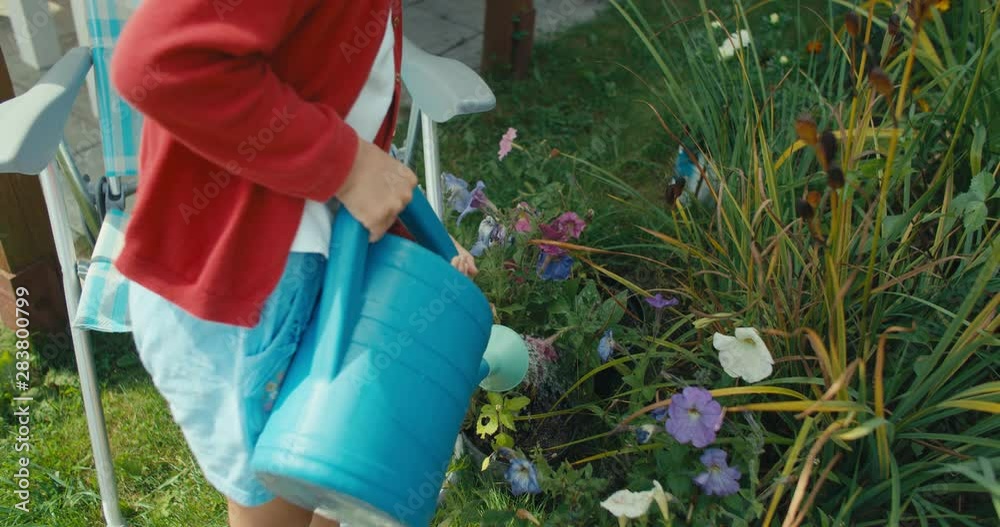 girl with blue plastic watering can girl with blue plastic watering can