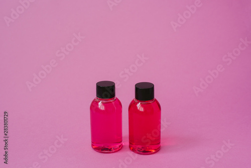 Cosmetic bottle for cosmetic product for care of skin or hair on a pink background. side view with copy space, banner or template. The concept of beauty product. Blank label for branding layout.