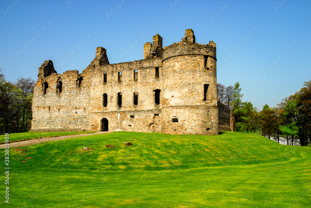 Exterior view of ruined Balvenie Castle with grass and cloudless blue sky Dufftown, Scotland, UK