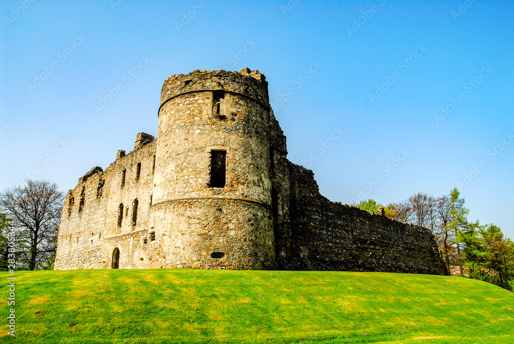 Exterior view of ruined Balvenie Castle with grass and cloudless blue sky Dufftown, Scotland, UK