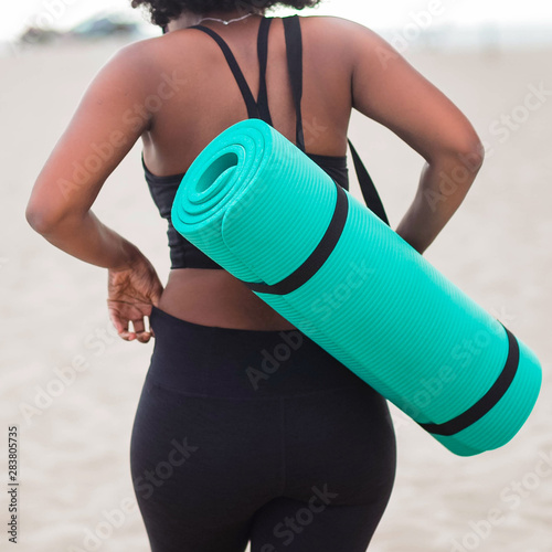 Rear view of woman carrying yoga mat